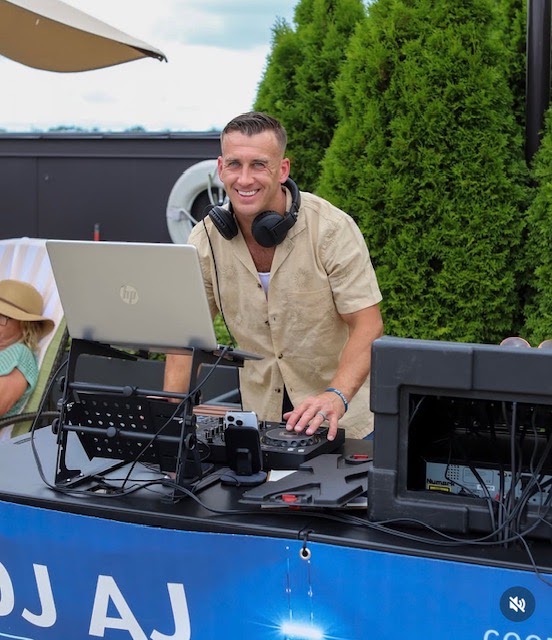 Behind the decks at a rooftop pool party.